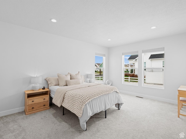 carpeted bedroom featuring baseboards and recessed lighting