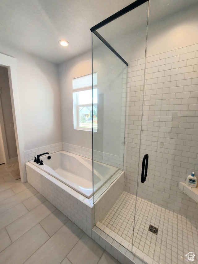 full bath featuring a bath, a shower stall, and tile patterned floors