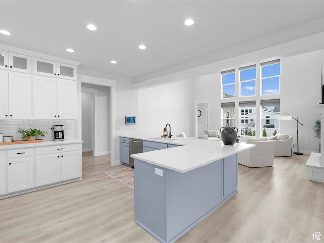 kitchen with a sink, stainless steel dishwasher, recessed lighting, white cabinets, and backsplash