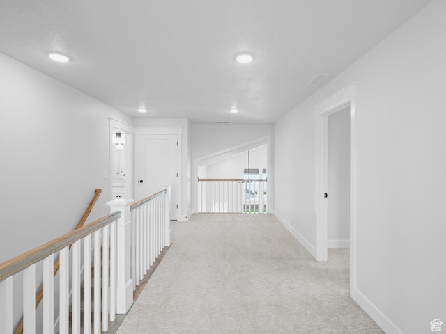 hallway featuring carpet flooring, recessed lighting, baseboards, and an upstairs landing