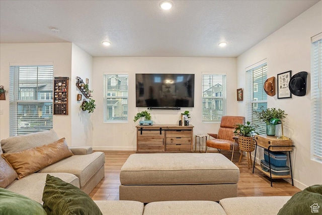 living area featuring light wood-type flooring, baseboards, and recessed lighting