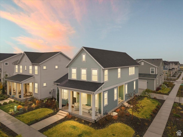 back of property featuring a garage, roof with shingles, a residential view, and covered porch
