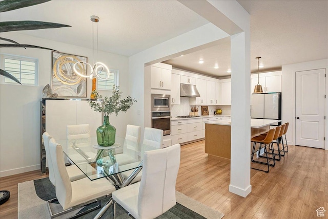 dining area featuring recessed lighting, baseboards, and light wood-type flooring