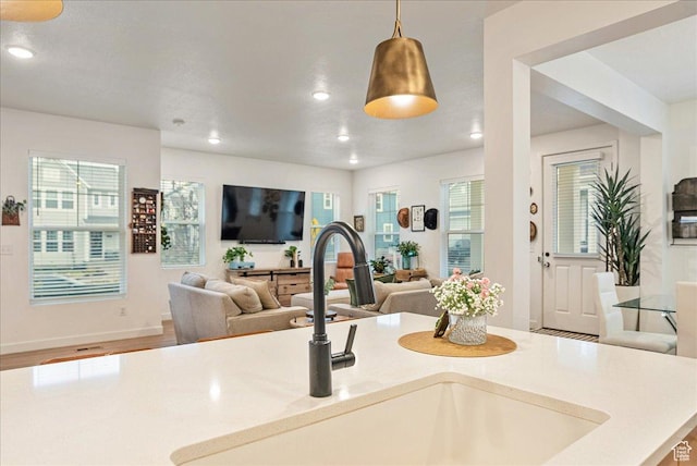 interior space with open floor plan, light countertops, a sink, and recessed lighting