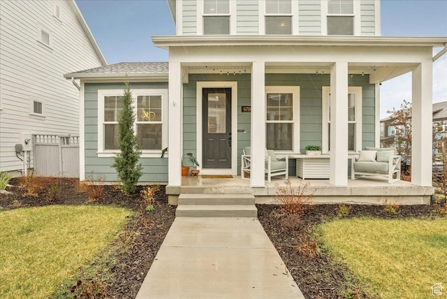entrance to property featuring a yard and covered porch
