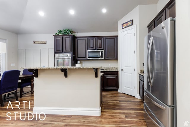 277 N Havenwood Dr W, Kaysville, UT 84037 - kitchen featuring dark brown cabinets, dark wood finished floors, appliances with stainless steel finishes, and a kitchen breakfast bar