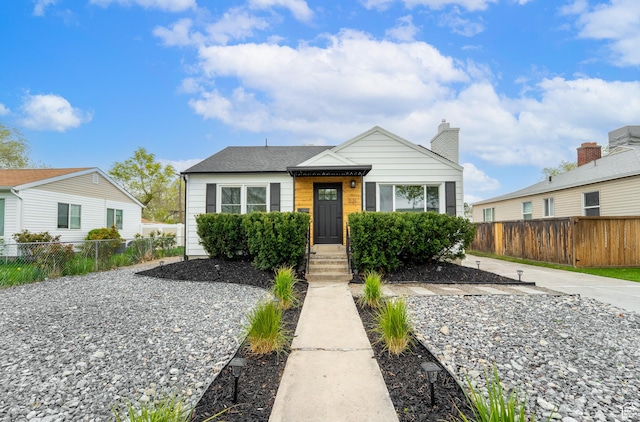 bungalow featuring fence and a chimney