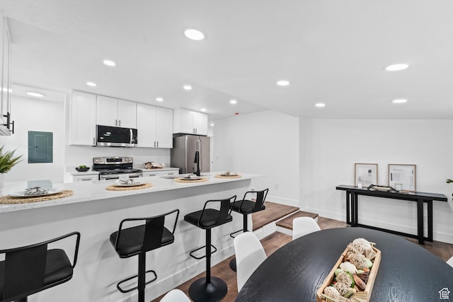 1131 W Simondi Ave N, Salt Lake City, UT 84116 - kitchen featuring white cabinets, recessed lighting, a kitchen breakfast bar, electric panel, and appliances with stainless steel finishes