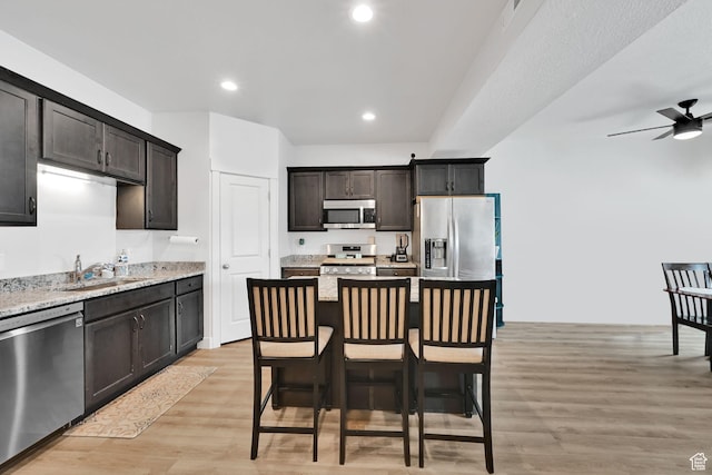 kitchen with a sink, recessed lighting, light wood finished floors, ceiling fan, and appliances with stainless steel finishes