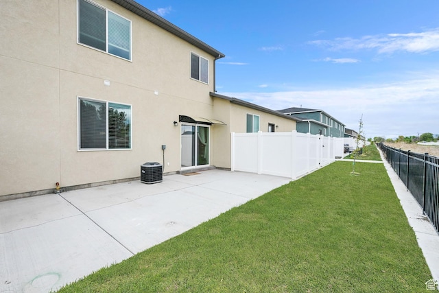 back of property featuring a yard, fence, a patio, and stucco siding