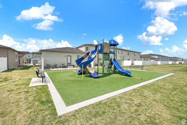 community playground with a yard, fence, and a residential view