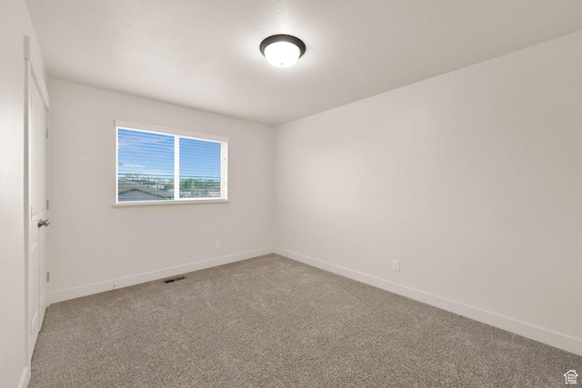 carpeted empty room with baseboards and visible vents