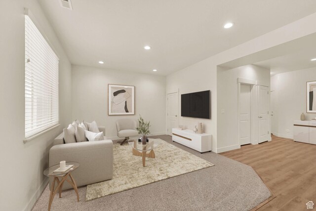living room with baseboards, recessed lighting, and light wood finished floors