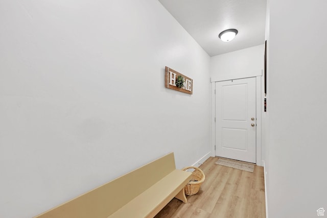 doorway to outside with light wood-style flooring and baseboards