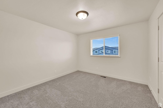 unfurnished room with carpet flooring, baseboards, and visible vents