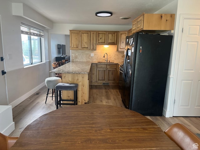 3415 W N Pln, City Road, Plain City, UT 84404 - kitchen with a peninsula, a sink, black fridge, baseboards, and light wood-style floors