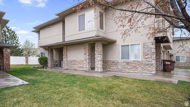 6661 W Merlot Way, West Jordan, UT 84081 - rear view of property featuring a patio area, stone siding, fence, a yard, and stucco siding