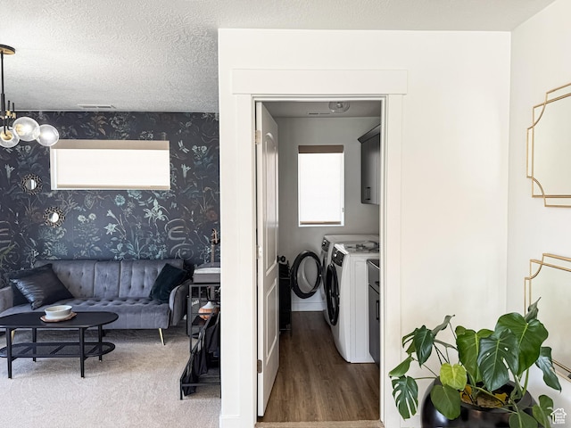 clothes washing area featuring wallpapered walls, wood finished floors, washer and dryer, and laundry area