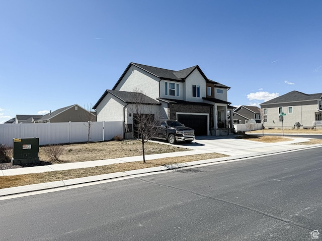 view of front of property with a residential view, concrete driveway, fence, an attached garage, and stucco siding