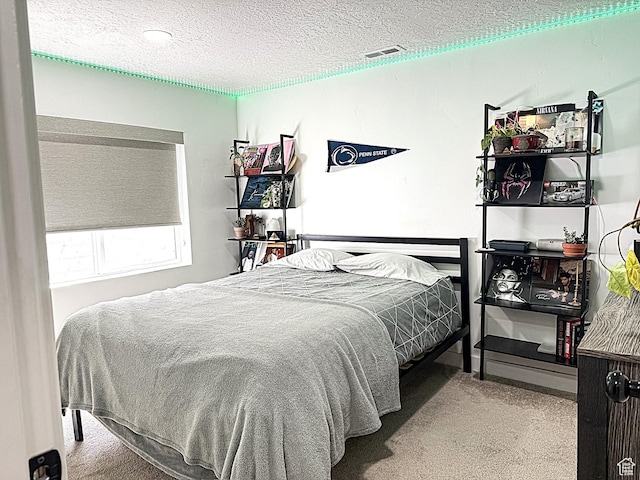 bedroom with visible vents, carpet, and a textured ceiling