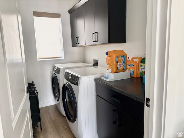 washroom with washer and dryer, baseboards, cabinet space, and light wood-type flooring