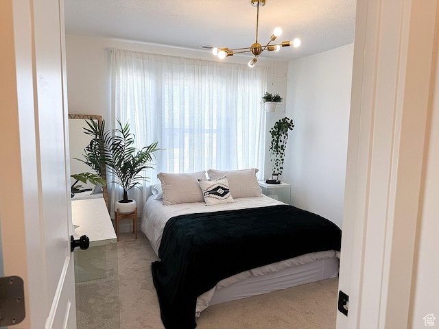 bedroom featuring carpet flooring and a notable chandelier