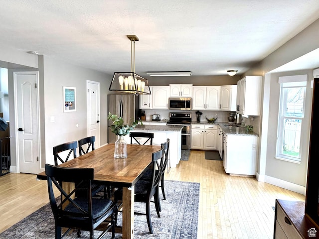 977 S Via La Costa Way, Kaysville, UT 84037 - dining space featuring light wood finished floors, baseboards, and a chandelier