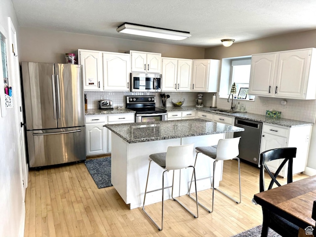 977 S Via La Costa Way, Kaysville, UT 84037 - kitchen featuring white cabinets, a sink, dark stone counters, decorative backsplash, and appliances with stainless steel finishes