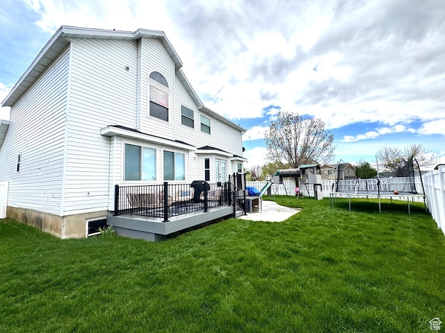 977 S Via La Costa Way, Kaysville, UT 84037 - rear view of property featuring a playground, a trampoline, a deck, fence, and a yard