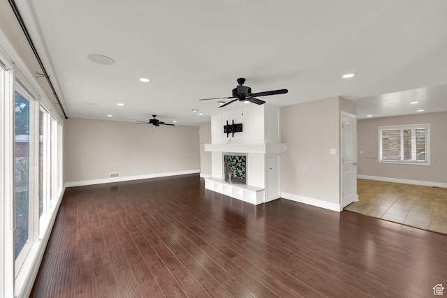 1936 E La Cresta Dr, Cottonwood Heights, UT 84121 - unfurnished living room with visible vents, baseboards, a fireplace with raised hearth, a ceiling fan, and wood finished floors