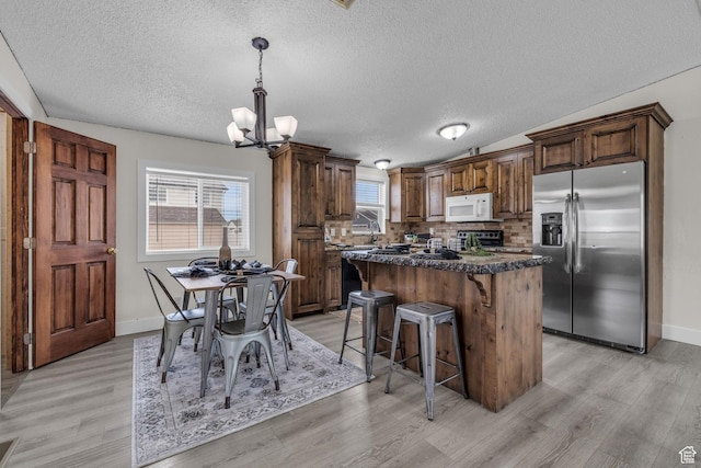 345 E 100 S, Coalville, UT 84017 - kitchen featuring a textured ceiling, a chandelier, a kitchen island, and stainless steel appliances