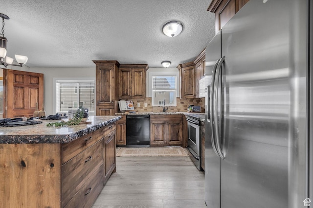 345 E 100 S, Coalville, UT 84017 - kitchen featuring stainless steel appliances, light wood-style floors, dark stone countertops, tasteful backsplash, and a textured ceiling