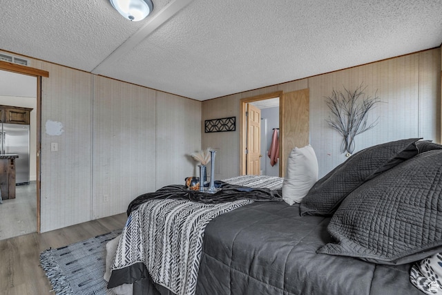 345 E 100 S, Coalville, UT 84017 - bedroom with wooden walls, wood finished floors, high quality fridge, and a textured ceiling