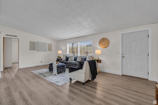 345 E 100 S, Coalville, UT 84017 - living area featuring light wood-style floors, visible vents, vaulted ceiling, baseboards, and a textured ceiling