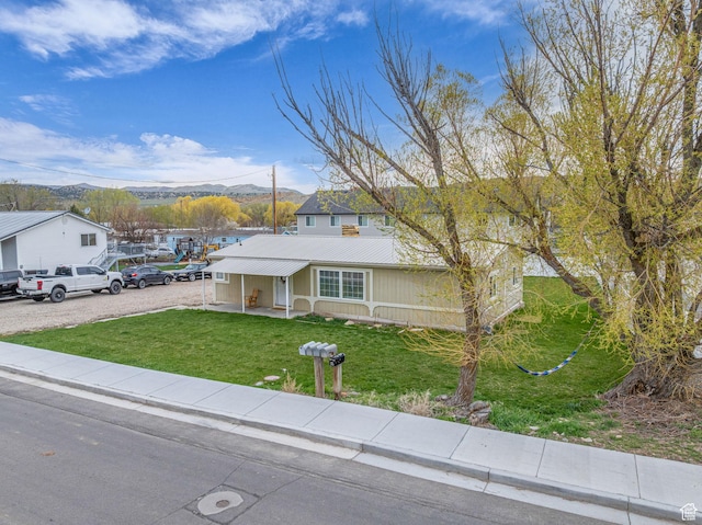 345 E 100 S, Coalville, UT 84017 - view of front of house with metal roof, a mountain view, and a front lawn