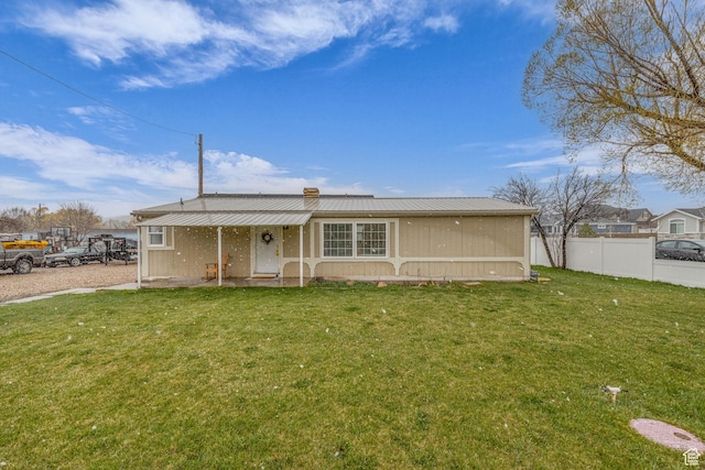 345 E 100 S, Coalville, UT 84017 - view of front of house featuring a chimney, fence, a front lawn, and metal roof