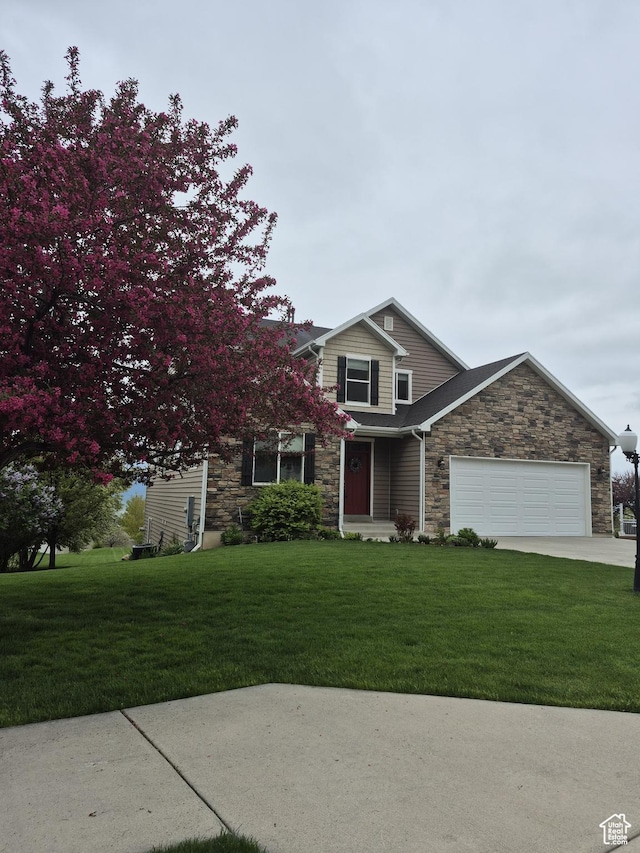 view of front facade with stone siding, an attached garage, a front yard, and concrete driveway