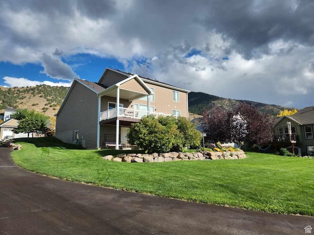 view of front of property with a mountain view and a front lawn