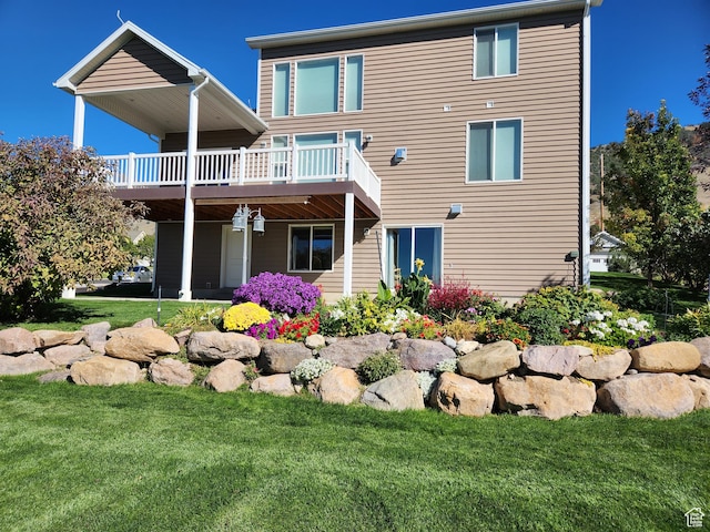 back of property with a wooden deck and a lawn