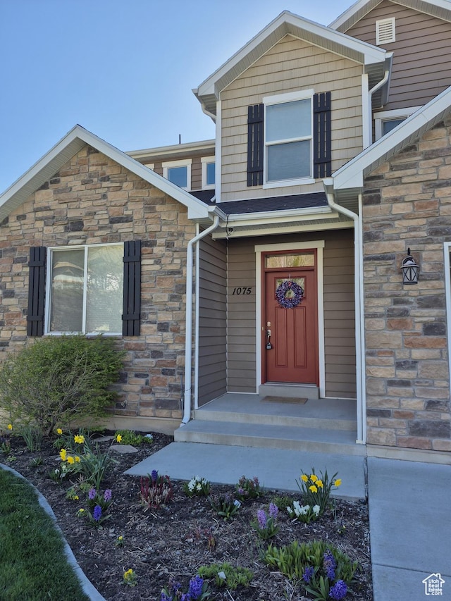 doorway to property with stone siding