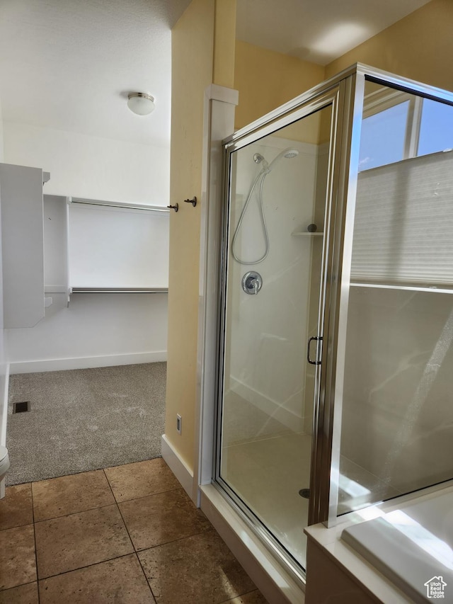 full bath featuring a shower stall, baseboards, and tile patterned floors