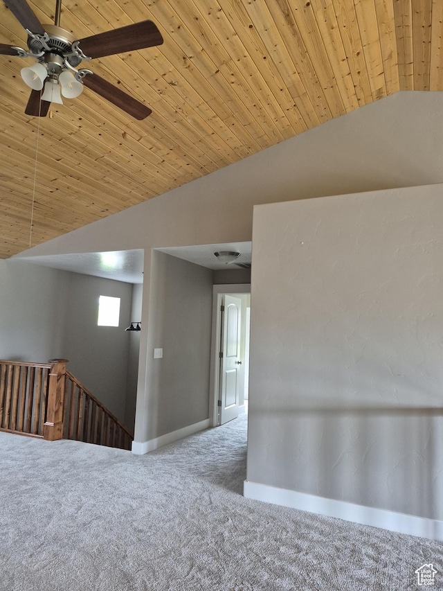 carpeted spare room with lofted ceiling, wood ceiling, baseboards, and ceiling fan