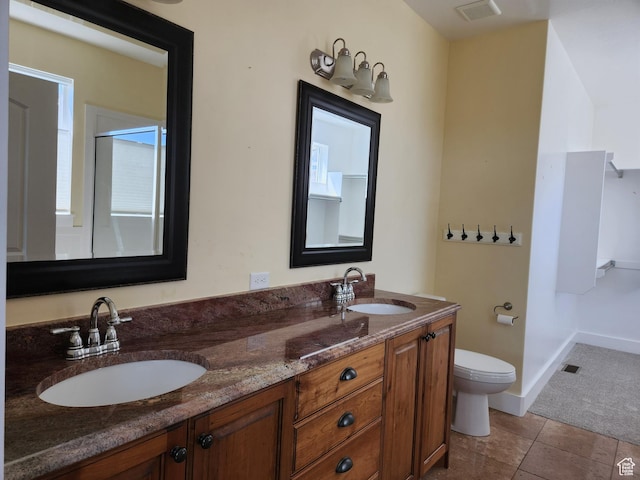 bathroom with double vanity, toilet, and baseboards