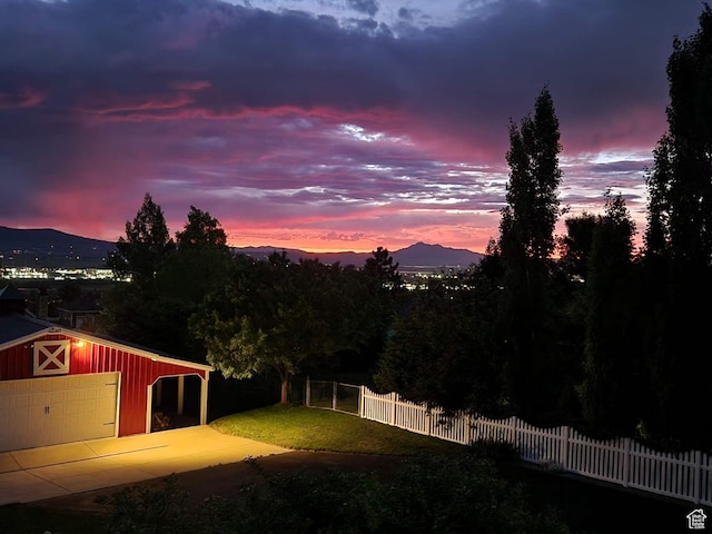 yard at dusk featuring an outdoor structure and a mountain view