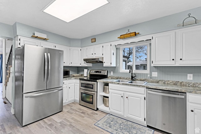 275 E 1st S, Preston, ID 83263 - kitchen featuring light wood finished floors, under cabinet range hood, a sink, and appliances with stainless steel finishes
