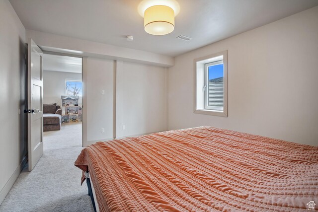 bedroom with visible vents, carpet floors, a closet, and multiple windows