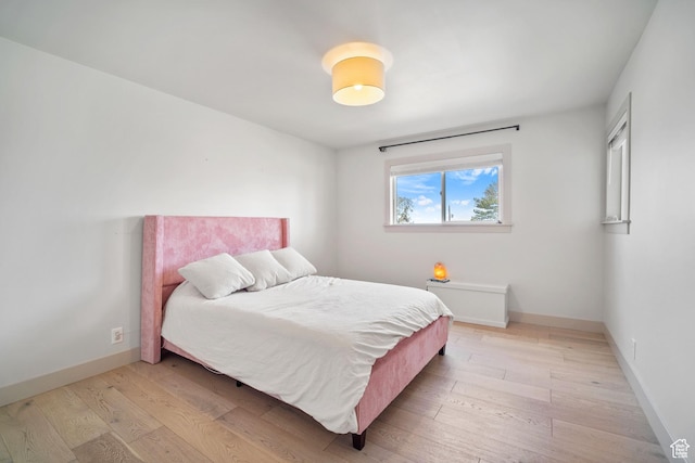 bedroom with baseboards and light wood-type flooring