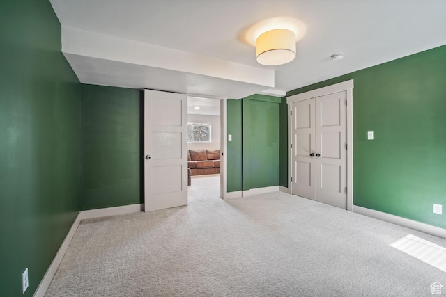unfurnished bedroom with baseboards, a closet, and carpet flooring