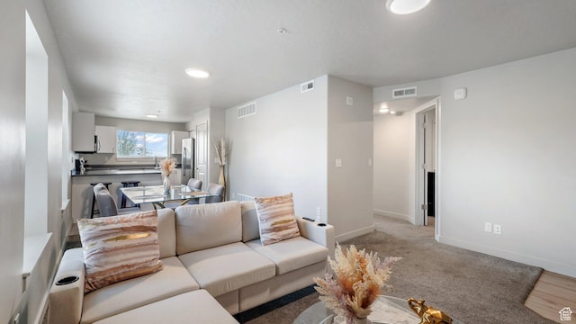 living room featuring baseboards and visible vents