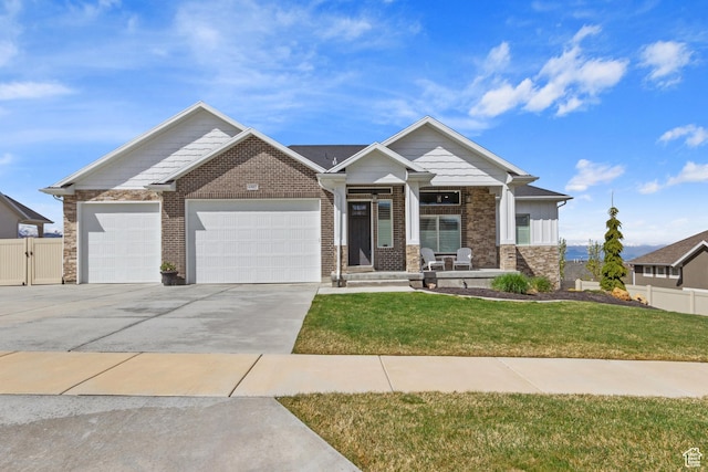 craftsman-style home featuring fence, a front lawn, concrete driveway, covered porch, and a garage